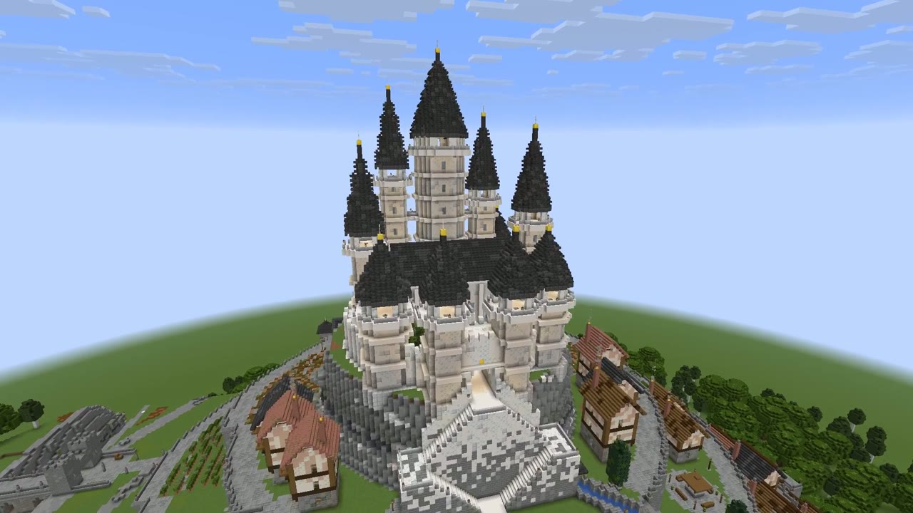 A white citadel with slender towers above a mountain town